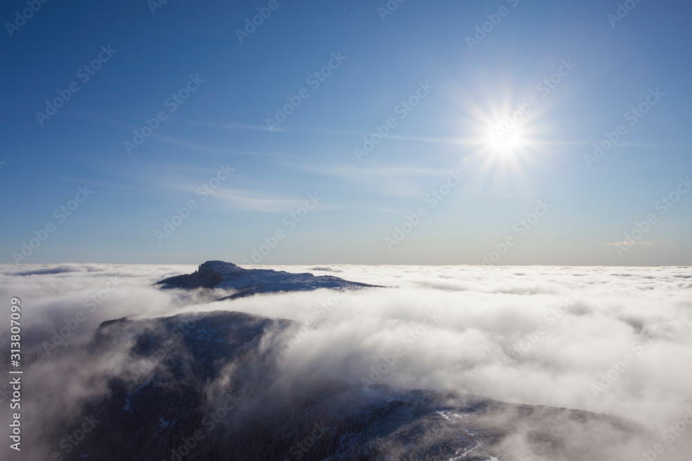 Ceahlau mountain with sun rays in winter landscape. Romania