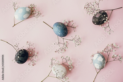 Photography Stylish easter eggs and spring flowers composition on pink paper flat lay, space for text