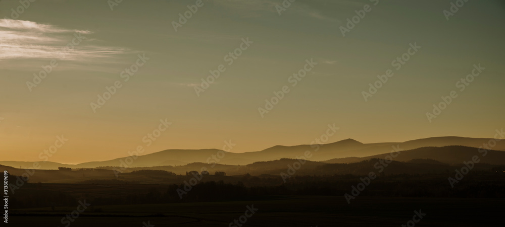rising sun panorama of meadows and hills