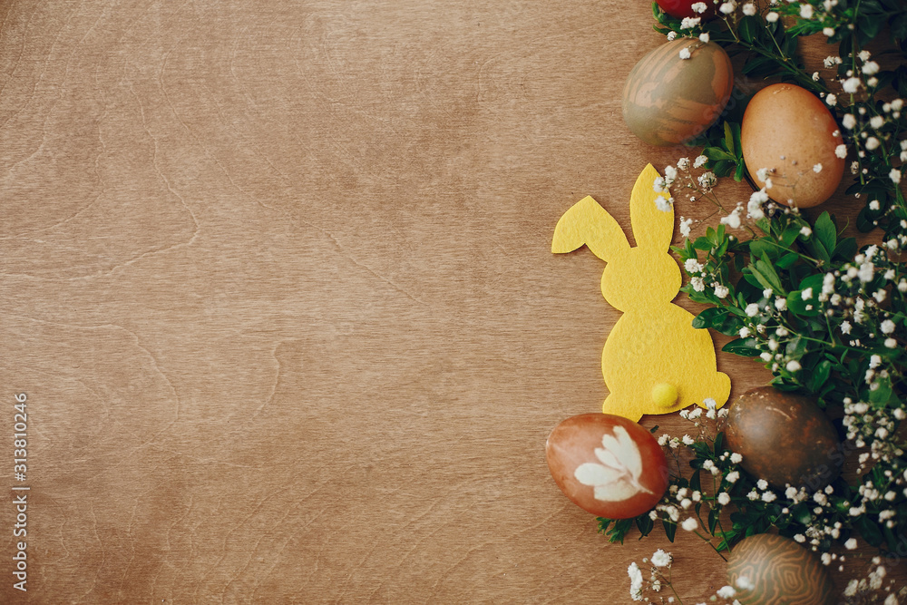 Happy Easter. Stylish easter eggs, yellow bunny, spring flowers on rustic wooden table flat lay, space for text. Natural dyed easter eggs and rabbit decorations on wood. Card mockup Happy Easter. Stylish easter eggs, yellow bunny, spring flowers on rustic wooden table flat lay, space for text. Natural dyed easter eggs and rabbit decorations on wood. Card mockup