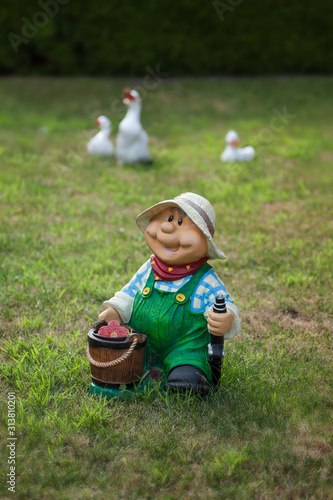 Garden gnome on lawn with goose sculpures in the background photo