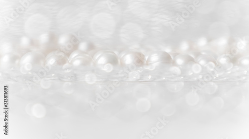Nature white string of pearls on a sparkling background in soft focus, with highlights