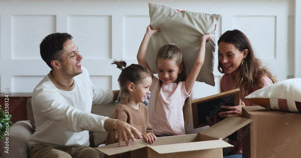 Excited family with kids unpacking boxes together on moving day Excited family with kids unpacking boxes together on moving day