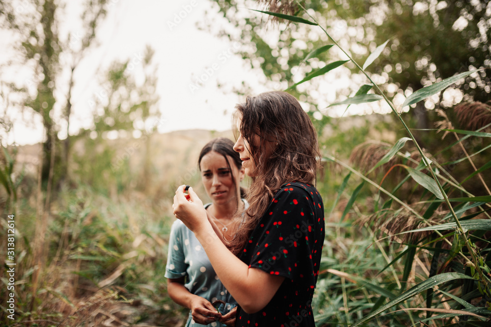 Fototapeta premium Two young women walking through the field