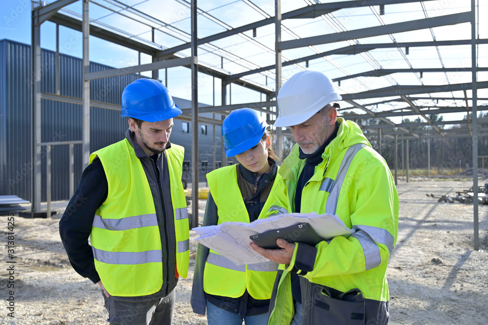 Engineering instructor working on building site with apprentice Engineering instructor working on building site with apprentice