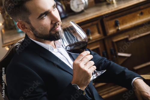 Handsome bearded man with a glass of red wine