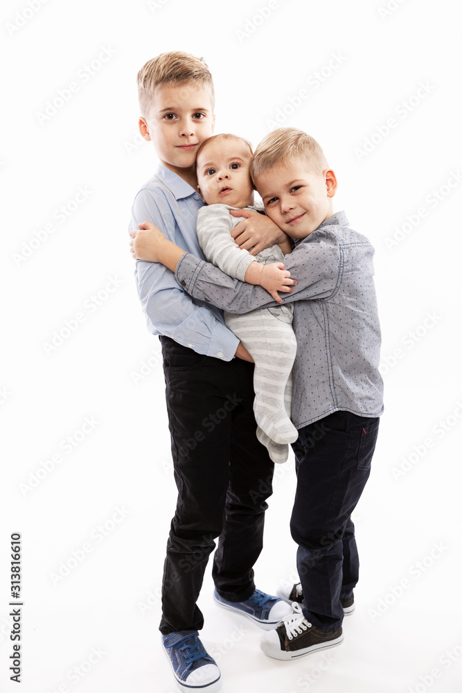 Two brothers are holding a newborn. Love and tenderness in the family. White background. Vertical. Two brothers are holding a newborn. Love and tenderness in the family. White background. Vertical.