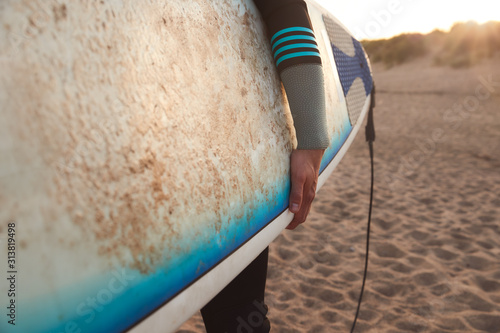 Photography Close Up Of Young Man Wearing Wetsuit Enjoying Surfing Staycation On Beach As Su