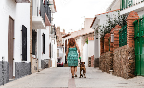 young woman walking down the street with boxer dog © DMegias