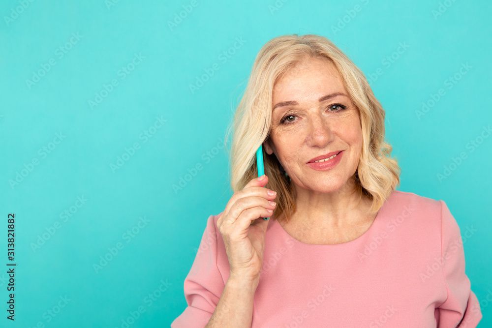 Woman adult talking phone in the blue studio Woman adult talking phone in the blue studio
