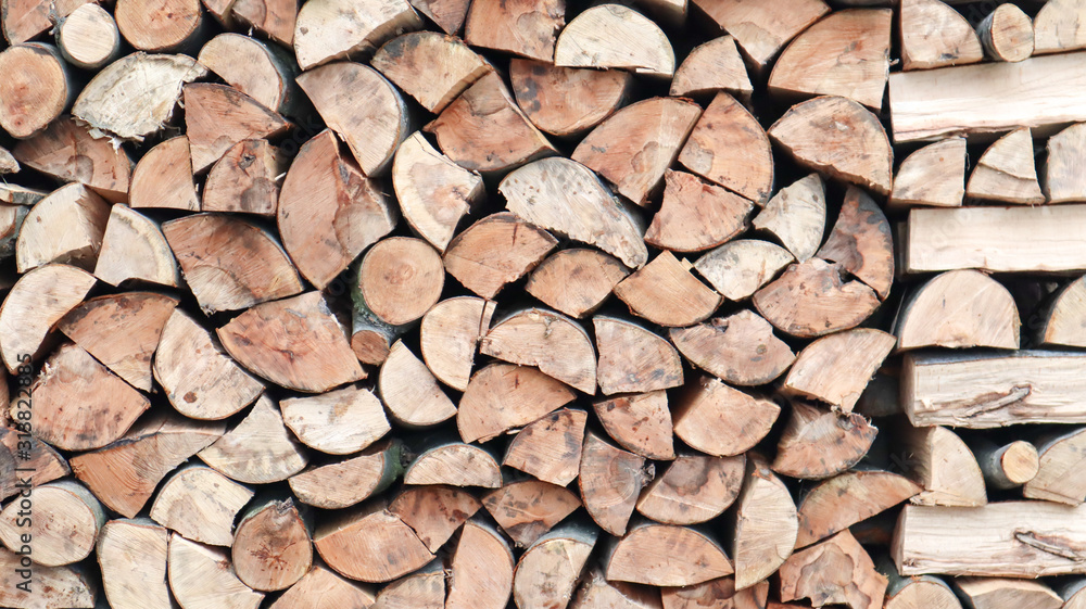 A neatly folded log of chopped wood. The fire is melting. Firewood stacked on top of each other. Firewood is collected for heating in cold weather. Background texture of stacked dry firewoods A neatly folded log of chopped wood. The fire is melting. Firewood stacked on top of each other. Firewood is collected for heating in cold weather. Background texture of stacked dry firewoods