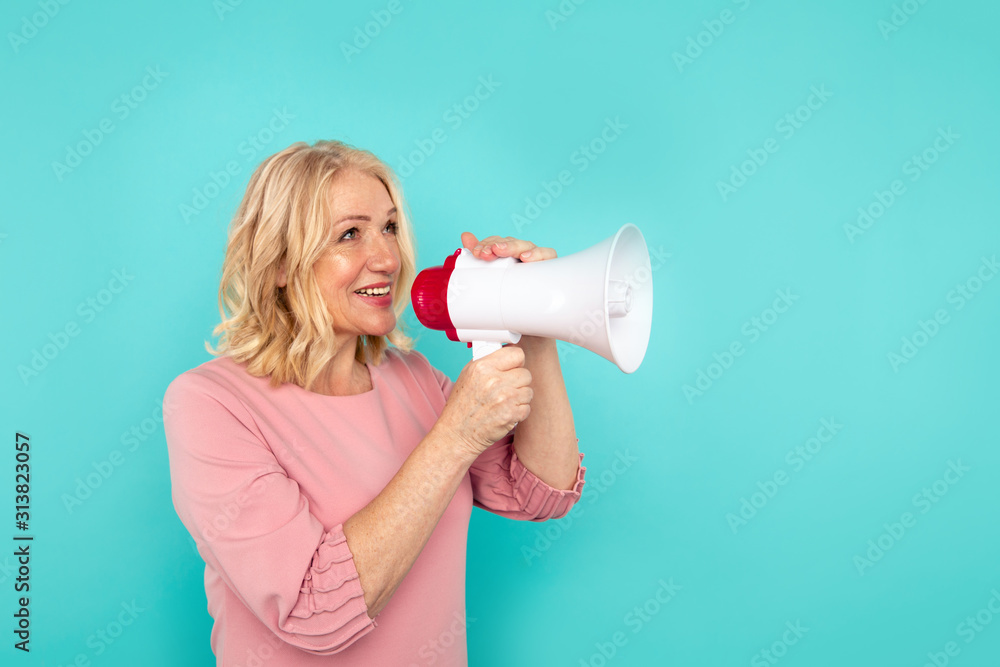 Woman with megaphone isolated in the blue studio Woman with megaphone isolated in the blue studio