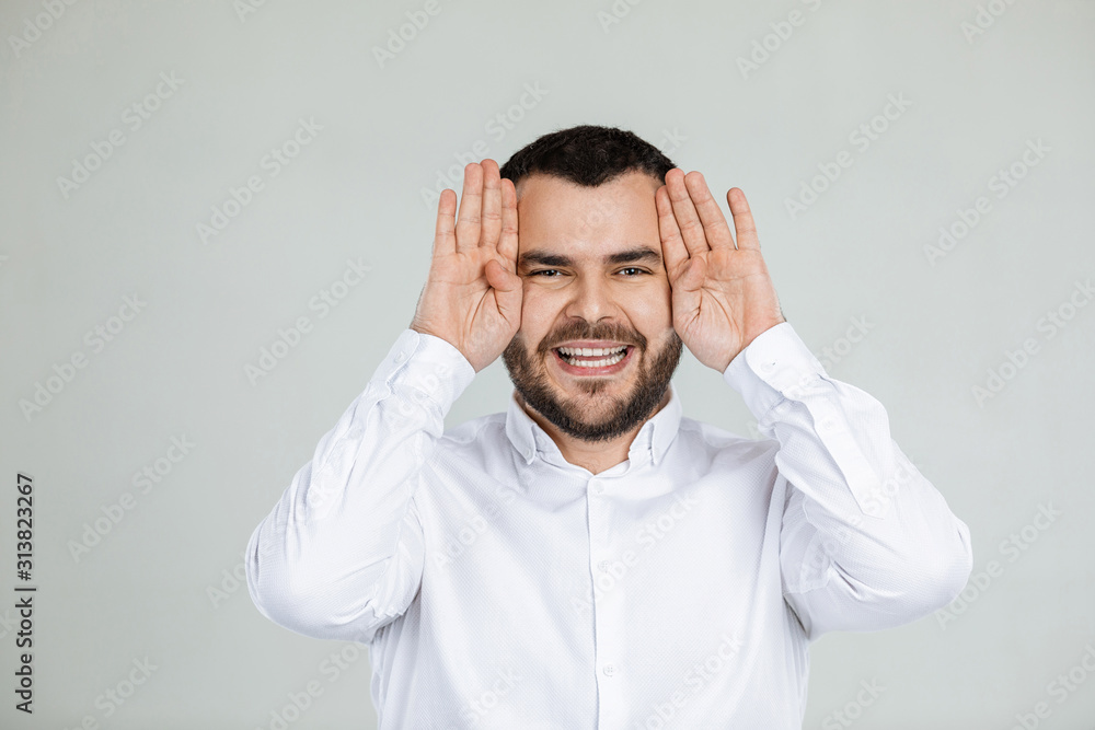 portrait of funny bearded man fooling around on gray background. man grimaced portrait of funny bearded man fooling around on gray background. man grimaced