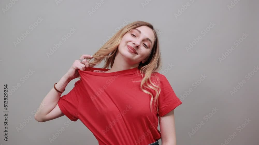 Crazy caucasian woman pulls shirt back with fingers, choking herself wearing fashion red shirt isolated on white background in studio. People sincere emotions, lifestyle concept. Crazy caucasian woman pulls shirt back with fingers, choking herself wearing fashion red shirt isolated on white background in studio. People sincere emotions, lifestyle concept.