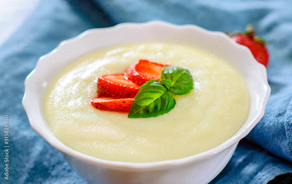 bowl of Semolina porridge with strawberries on wooden table bowl of Semolina porridge with strawberries on wooden table