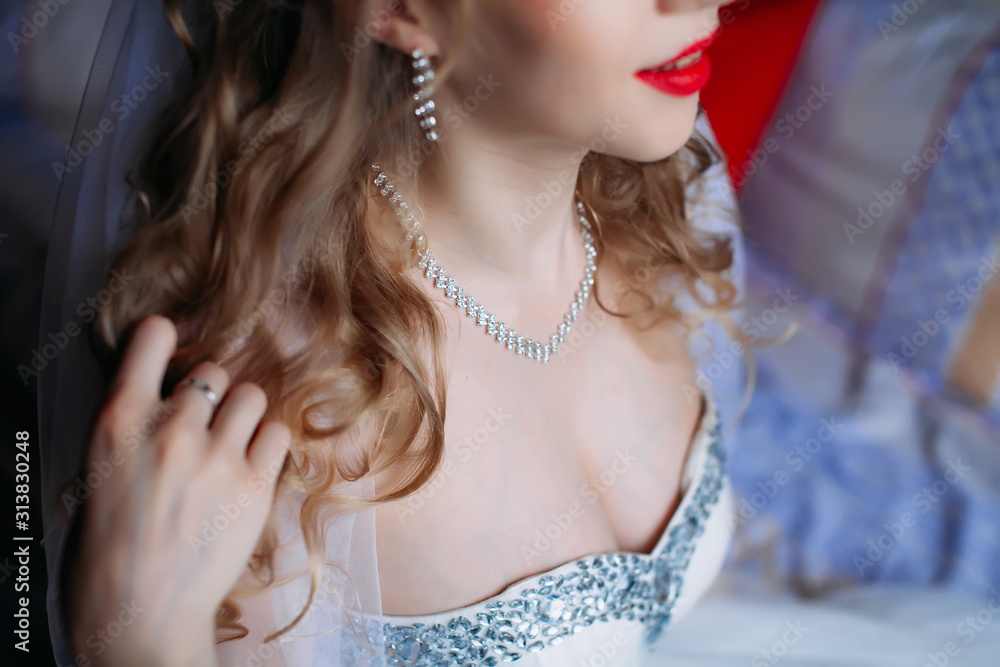 Portrait of a bride in a white dress with red lips