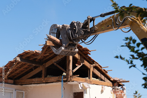 industrial excavator working demolition of house old residential building