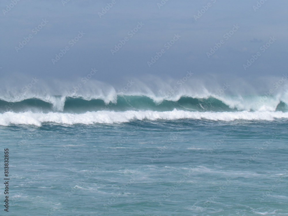 Fototapeta premium Summer morning at the beach with high tide and high winds.