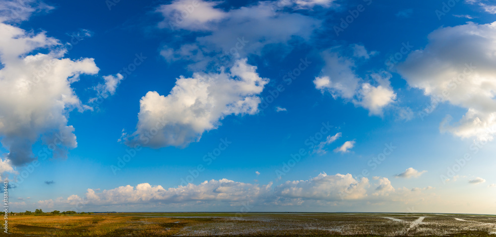 Panorama of a beautiful blue sky filled with white clouds over the big lake at Thale Noi Waterfowl Reserve nonihunting area , the famous for its attractions in Thailand.