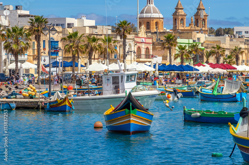 The traditional eyed boats in the harbor of fishing village Marsaxlokk in Malta photo