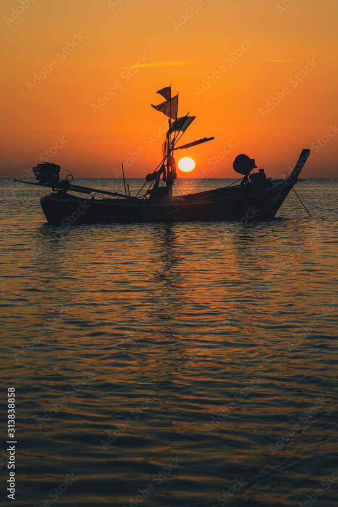 Atmosphere of the beach at sunset, fishing boats moored on the sandy beach