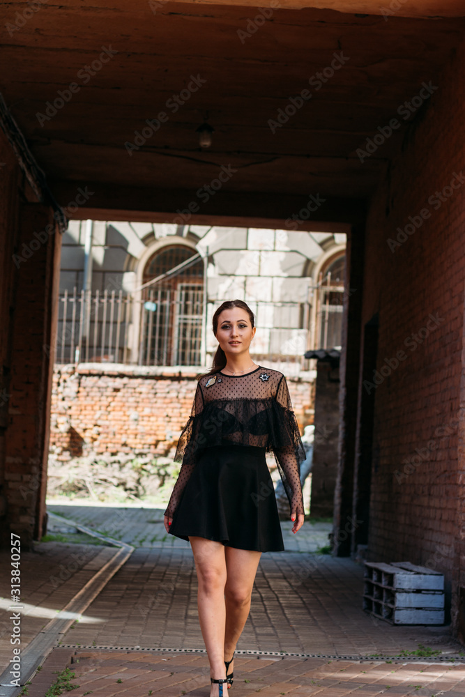the girl is posing smiles. Emotional portrait of Fashion stylish portrait of pretty young woman. city portrait. brunette in a black dress with stars and planets on a dress. expectation. dreams