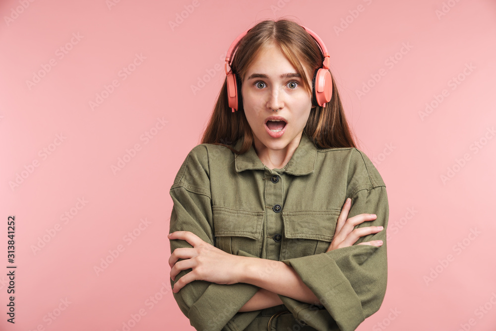 Photo of surprised woman using headphones and looking at camera Photo of surprised woman using headphones and looking at camera