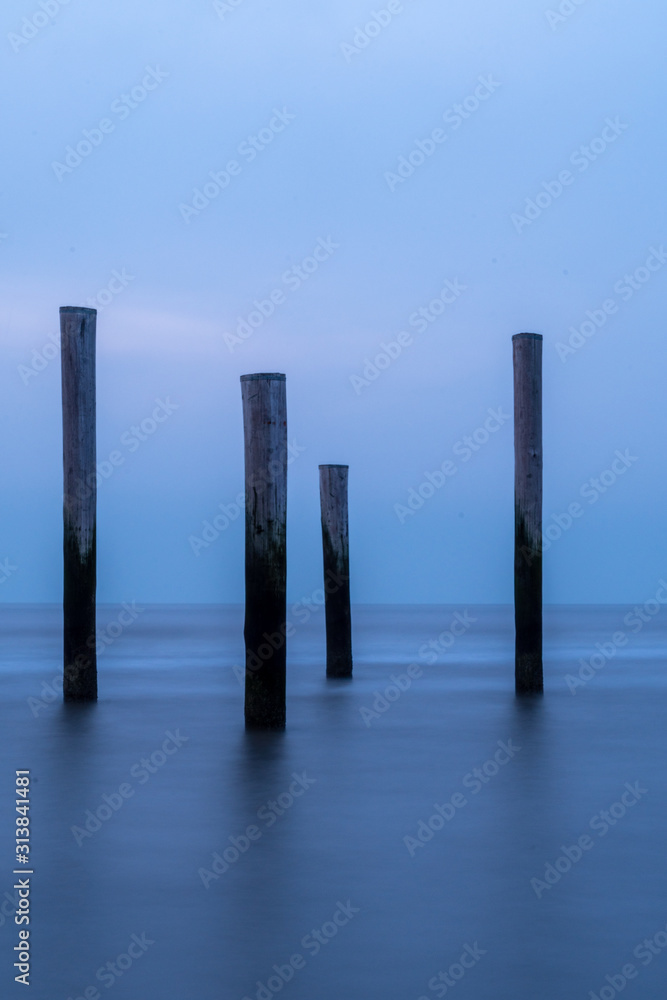Poles at the sea during blue hour