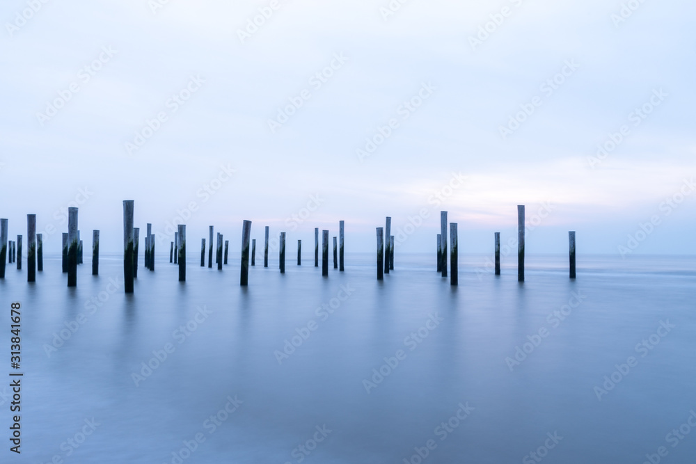 Poles at the sea during blue hour Poles at the sea during blue hour