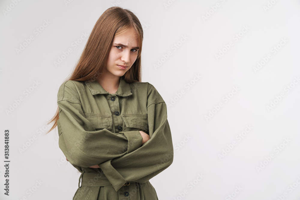 Photo of displeased young woman looking at camera with hands crossed Photo of displeased young woman looking at camera with hands crossed