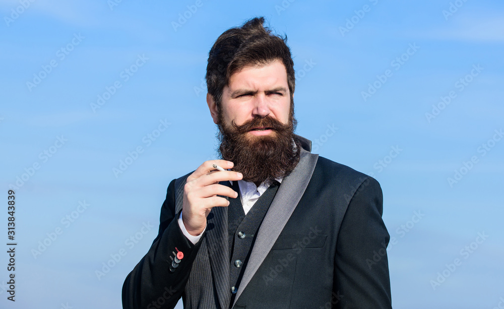 Relaxing but harmful habit. Man with beard and mustache hold cigarette.  Bearded hipster smoking cigarette blue sky background. Guy with cigarette  enjoy nicotine influence. Pleasure of smoking Photos | Adobe Stock