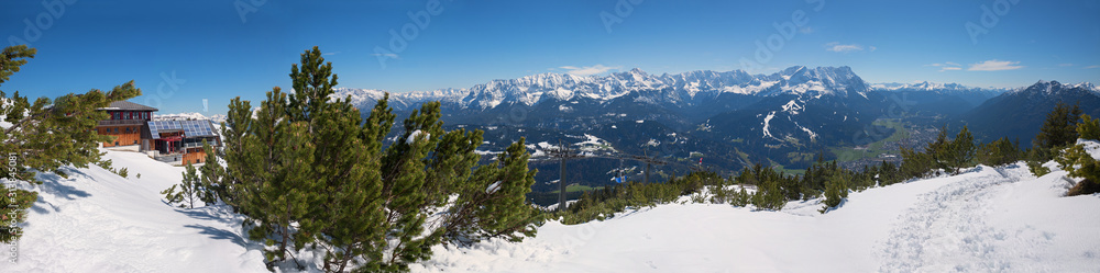 wintry landscape at Wank mountain, view to Zugspitze and tourist resort Garmisch-Partenkirchen, wooden alp hut