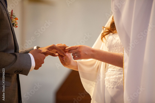 Mariés qui se passent la bague au doigt le jour du mariage dans l'église photo