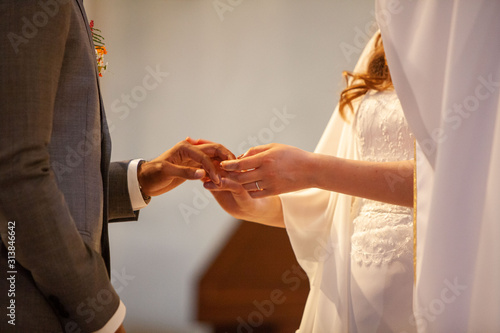 Mariés qui se passent la bague au doigt le jour du mariage dans l'église