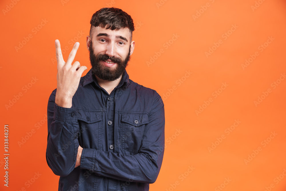 Image of brunette man with nose jewelry showing two fingers at camera Image of brunette man with nose jewelry showing two fingers at camera