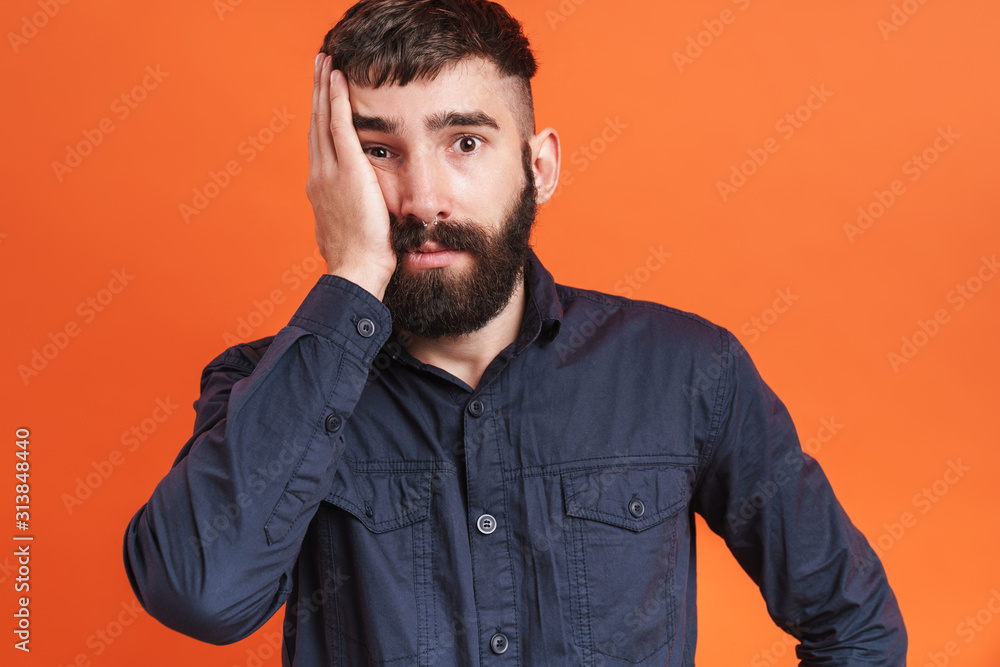 Image closeup of confused man with nose jewelry grabbing his face Image closeup of confused man with nose jewelry grabbing his face