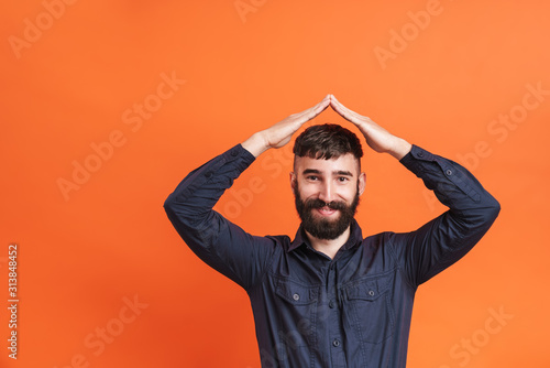 Image of man holding two hands above his head and making roof gesture © Drobot Dean