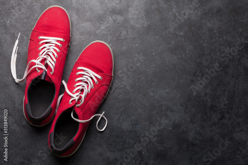 Pair of red sneakers over stone