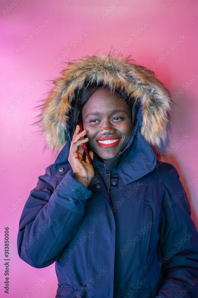 Black woman portrait over pink background talking with smartphone Black woman portrait over pink background talking with smartphone