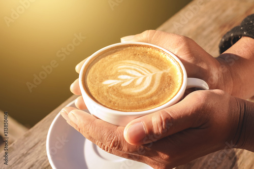 Close up of hands holding a cup of coffee to drink increase energy for today