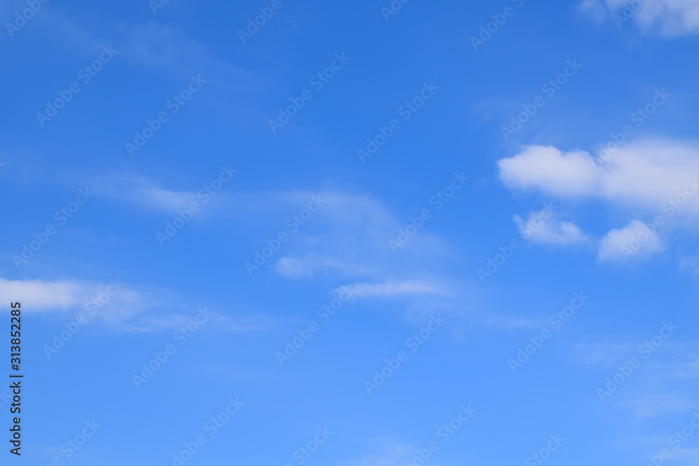 Clear blue sky background with white clouds