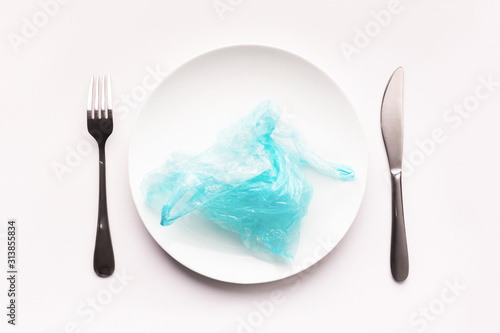 Plate with plastic bag instead of food isolated on white photo