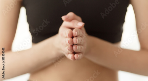 Woman practicing yoga, holding hands together and praying