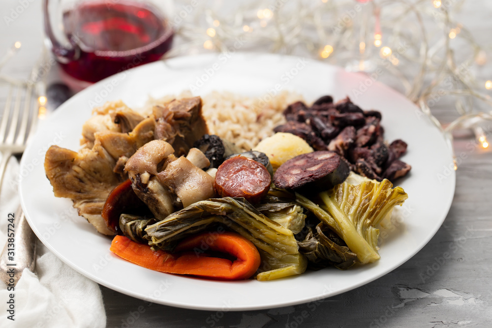 typical portuguese dish boiled meat, smoked sausages, vegetables and rice on white plate