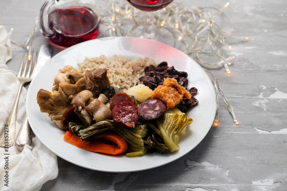 typical portuguese dish boiled meat, smoked sausages, vegetables and rice on white plate