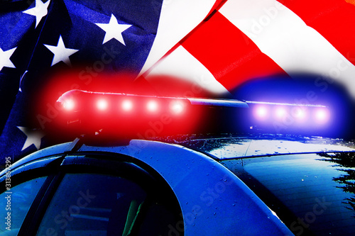 Road police patrol car with lightbar alarm emergency on the street of city at night. Flashing blue and red police car led lights in night darkness on American flag with copyspace for text.  © Vlyaks