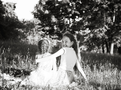 Two Happy cute little girls laughing and hugging at the summer park. Happy chidhood concept. Black and white photo. photo