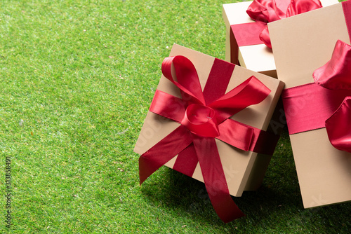 Present boxes with red ribbon on grass floor