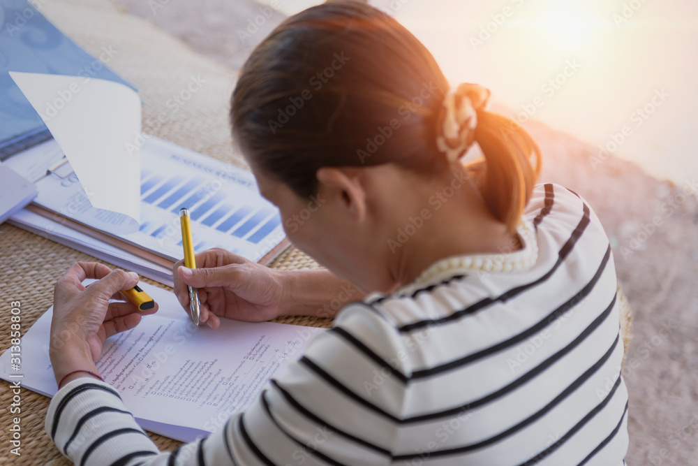 Young woman at work, reading and writing some papers on the desk. Home office. Young woman at work, reading and writing some papers on the desk. Home office.
