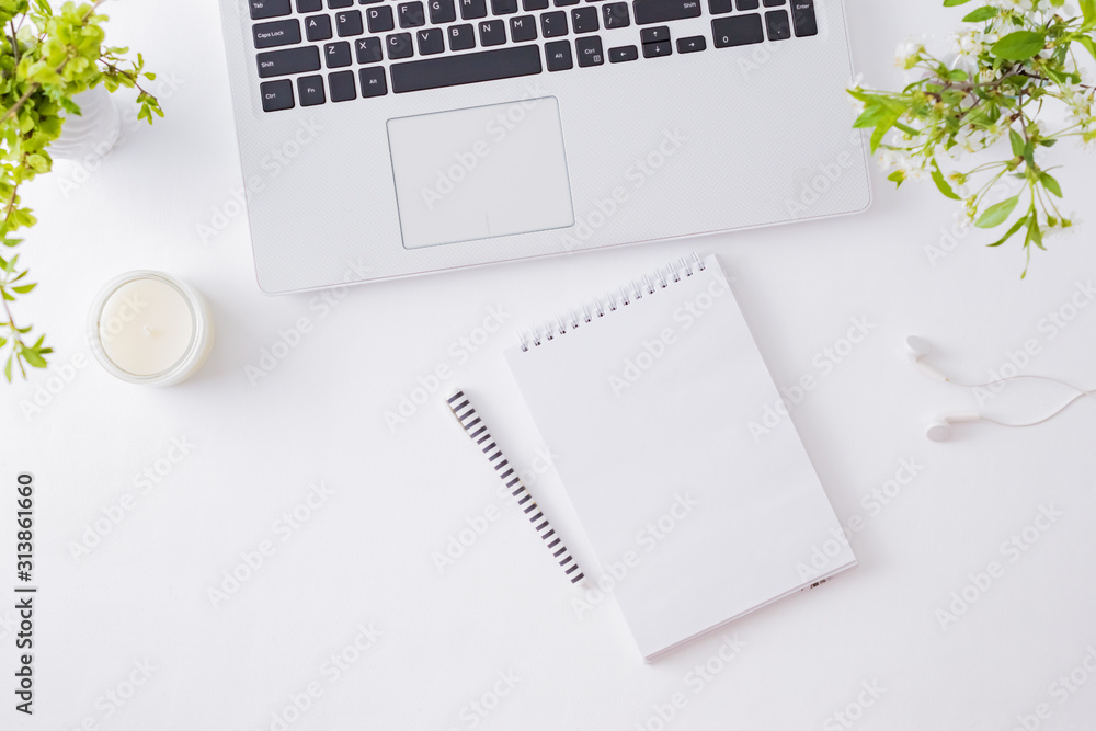 Flat lay blogger or freelancer workspace with a laptop, spring flowers, office supplies on a light background Flat lay blogger or freelancer workspace with a laptop, spring flowers, office supplies on a light background